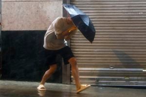 Un hombre con un paraguas lucha contra el fuerte viento y la lluvia traídos por el súper tifón Saola en Hong Kong, el viernes 1 de septiembre de 2023.