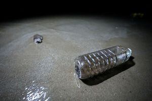 Mancha de aceite en una botella de plástico causada por una fuga de un oleoducto submarino a 20 km ) de la costa este de Tailandia en la playa de Mae Ramphueng en la provincia de Rayong, Tailandia, 28 de enero de 2022. REUTERS/Athit Perawongmetha