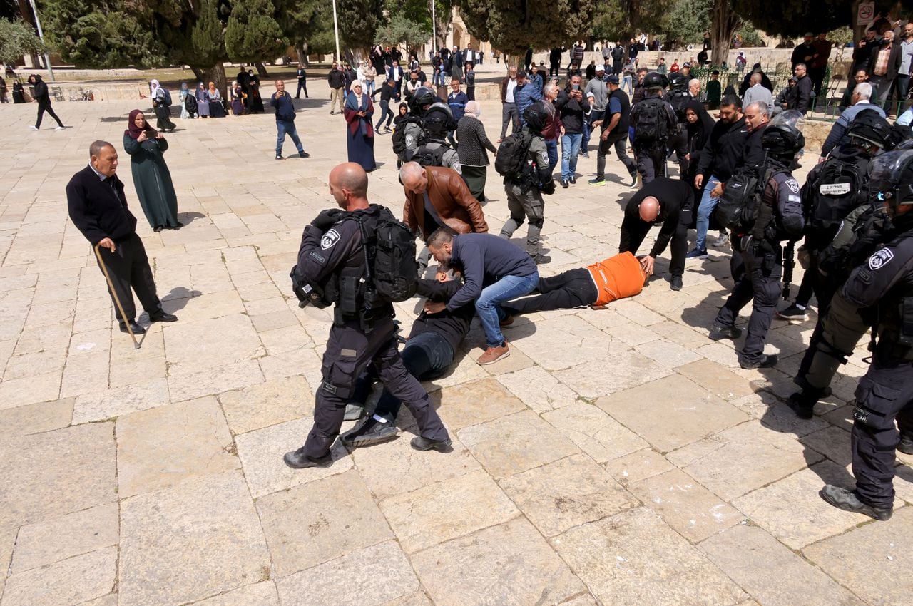 Dos personas yacen en el suelo durante los enfrentamientos entre las fuerzas de seguridad israelíes y los palestinos el 5 de mayo de 2022 luego de una visita de un grupo de judíos al complejo de la mezquita de al-Aqsa, que es el tercer lugar más sagrado del Islam y el lugar más sagrado del judaísmo. , conocido por los judíos como el Monte del Templo, en la Ciudad Vieja de Jerusalén. - Estallaron enfrentamientos entre israelíes y palestinos en el recinto de la mezquita Al-Aqsa de Jerusalén, después de un enfriamiento de las tensiones de 10 días en el lugar sagrado, dijo la policía israelí. La policía israelí dijo que había repelido a "docenas de alborotadores" que habían estado "arrojando piedras y otros objetos” a las fuerzas de seguridad. (Foto de AHMAD GHARABLI / AFP)
