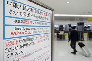 NARITA, JAPAN - JANUARY 17: A passenger walks past a notice for  passengers from Wuhan, China displayed near a quarantine station at Narita airport on January 17, 2020 in Narita, Japan. Japan's Ministry of Health, Labour and Welfare confirmed yesterday its first case of pneumonia infected with a new coronavirus from Wuhan City, China. (Photo by Tomohiro Ohsumi/Getty Images)