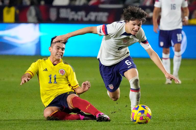 United States' Paxten Aaronson, right, dribbles past Colombia's Daniel Ruiz during the second half of an international friendly soccer match Saturday, Jan. 28, 2023, in Carson, Calif. (AP Photo/Marcio Jose Sanchez)