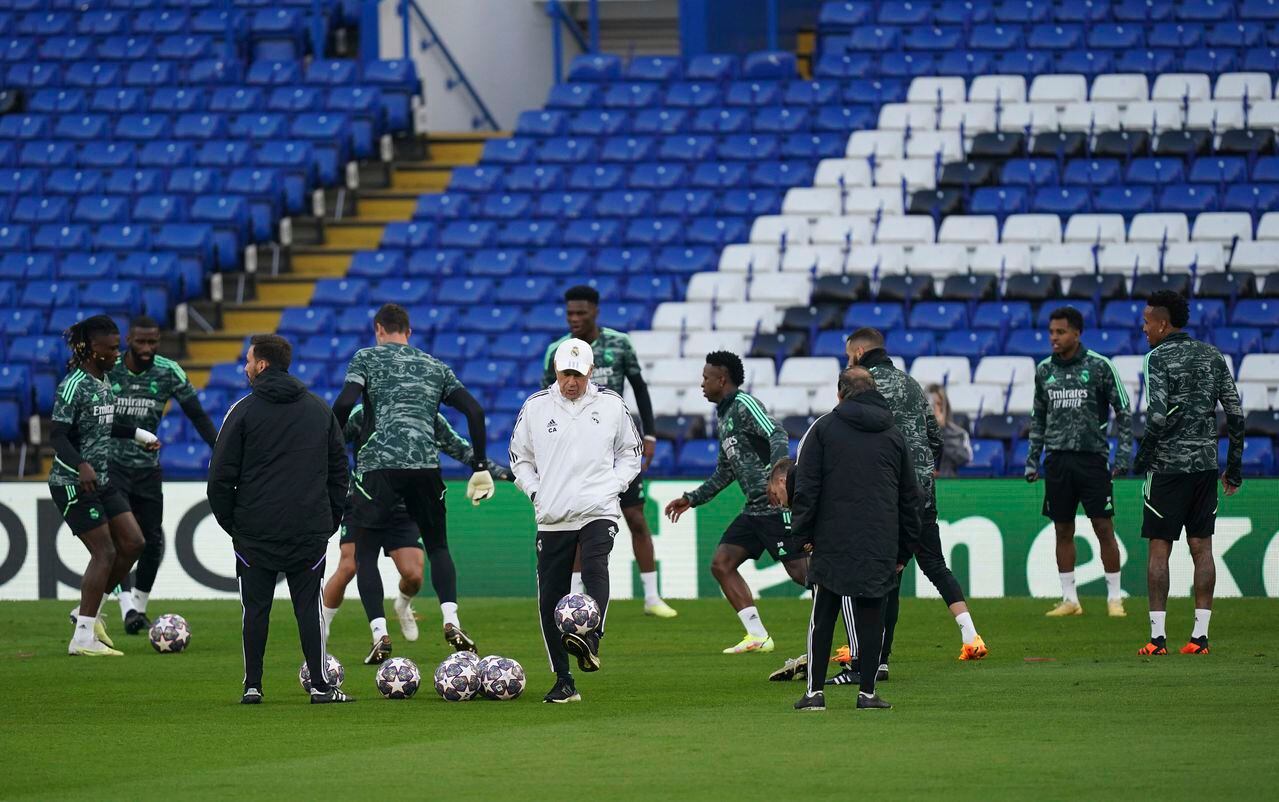Real Madrid manager Carlo Ancelotti, centre, plays with a ball while Real Madrid players train at Stamford Bridge, the day ahead of their UEFA Champions League quarterfinal soccer match against Chelsea FC, in London, Monday April 17, 2023. (John Walton/PA via AP)