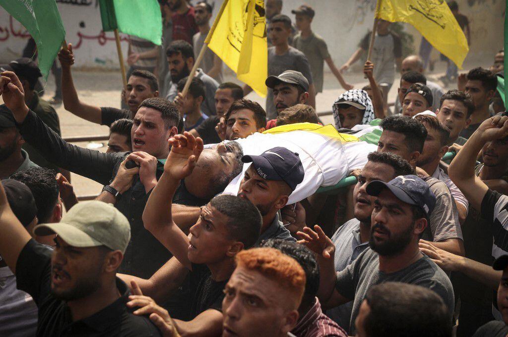 Los dolientes palestinos llevan el cuerpo de Ibrabim Abu Salah, de 45 años de edad, durante su funeral en Beit Hanoun, en el norte de la Franja de Gaza, el 10 de agosto de 2022 después de que una tregua detuviera el conflicto mortal entre el ejército israelí y los militantes de la Yihad Islámica en el enclave costero palestino de Gaza. . (Foto de Mahmud JAMONES / AFP)