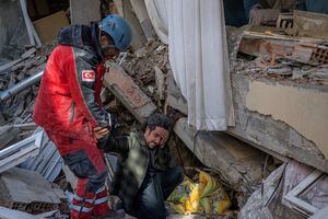 Un hombre suplica a un rescatista que salve a su hermano en Hatay, sureste de Turquía, el 8 de febrero de 2023, dos días después de que un fuerte terremoto azotara la región. (Foto de BULENT KILIC / AFP)