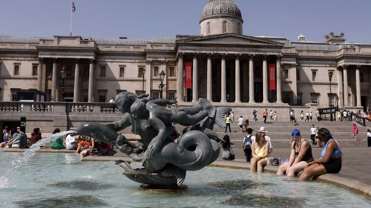 La gente se refresca junto a las fuentes de Trafalgar Square en el centro de Londres el 17 de junio de 2022, en el día más caluroso del año hasta ahora en la capital. (Foto de CARLOS JASSO / AFP)