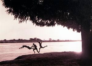 Bañistas en el Magdalena. Nereo López captura el momento exacto en el que tres jóvenes se zambullen en las aguas de este caudaloso río con un atardecer de fondo. Cortesía del Museo de Arte Moderno de Barranquilla.