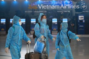Personas con equipo de protección completo caminan por el aeropuerto Noi Bai en Hanoi, Vietnam, el viernes 12 de febrero de 2020. Un nuevo brote de COVID-19 en Vietnam ha ralentizado los negocios y los viajes durante el popular festival del año nuevo lunar. (Foto AP / Hau Dinh)
