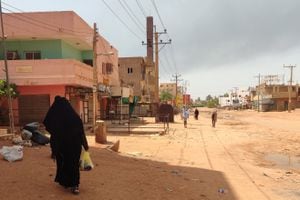 La gente camina frente a las tiendas en Jartum el 9 de junio de 2023, en medio de los combates en curso.