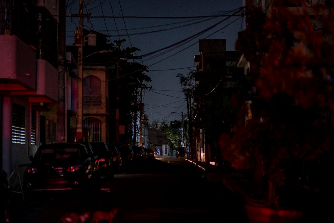 (ARCHIVOS) En esta foto de archivo tomada el 6 de abril de 2022, se ven los faros de un automóvil en una calle oscura en San Juan, Puerto Rico, después de un gran corte de energía en la isla. - La mayoría de las personas en Puerto Rico se despertaron el 7 de abril de 2022 sin electricidad después de que un apagón afectó a todo el territorio insular de los EE. UU. en el Caribe. (Foto de Ricardo ARDUENGO / AFP)