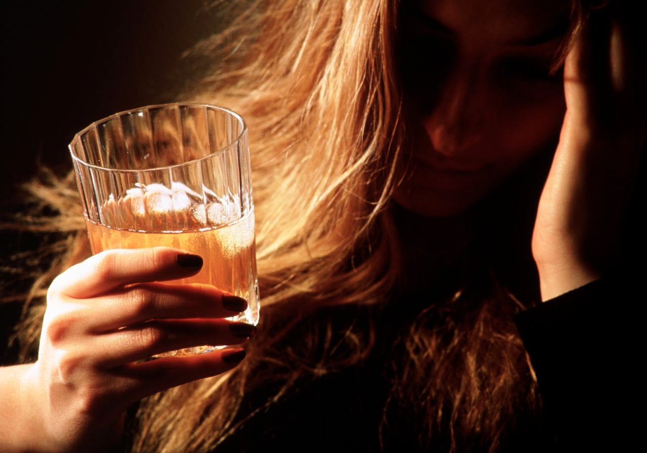 Una mujer con dolor de cabeza por consumo de alcohol