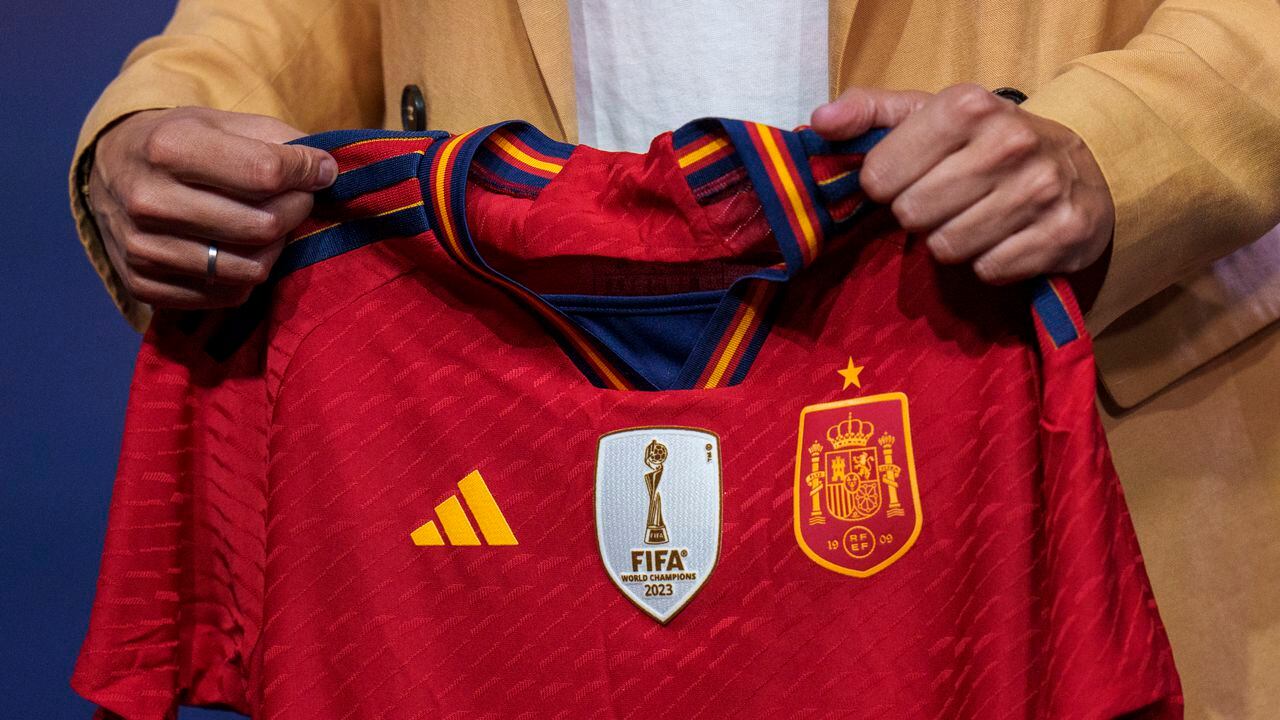 La nueva seleccionadora femenina absoluta de España, Montse Tomé, sostiene una camiseta del equipo en su presentación oficial, en la sede de la Federación Española de Fútbol en Las Rozas, Madrid, el 18 de septiembre de 2023. (AP Foto/Manu Fernández)