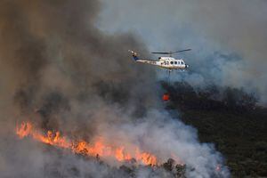 Un helicóptero trabaja en la contención de un incendio forestal durante la segunda ola de calor del año en las inmediaciones de Guadapero, España, 15 de julio de 2022. Foto REUTERS/Susana Vera 