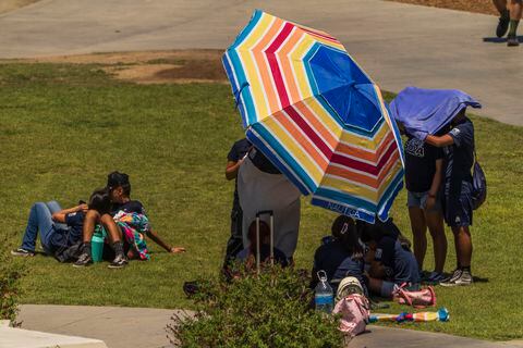 Los estudiantes intentan protegerse de la luz del sol en los jardines del Observatorio Griffith en Los Ángeles el viernes 14 de julio de 2023. Más de un tercio de los estadounidenses están bajo avisos, alertas y advertencias de calor extremo a medida que continúa una ola de calor abrasadora en el suroeste y California.