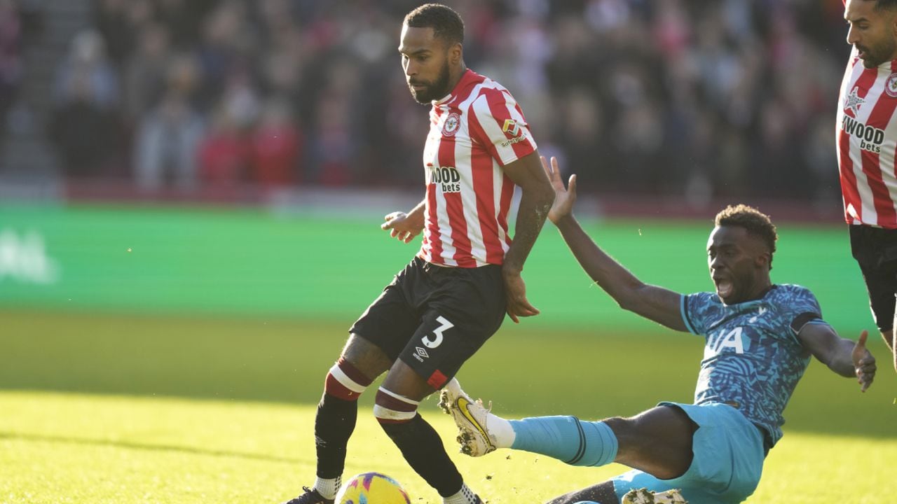 Brentford's Rico Henry, left, and Tottenham's Davinson Sanchez challenge for the ball during the English Premier League soccer match between Brentford and Tottenham Hotspur at the Gtech Community Stadium in London, Monday, Dec. 26, 2022. (AP/Kirsty Wigglesworth)