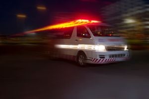 Ambulancia de emergencia a toda velocidad por la ciudad por la noche