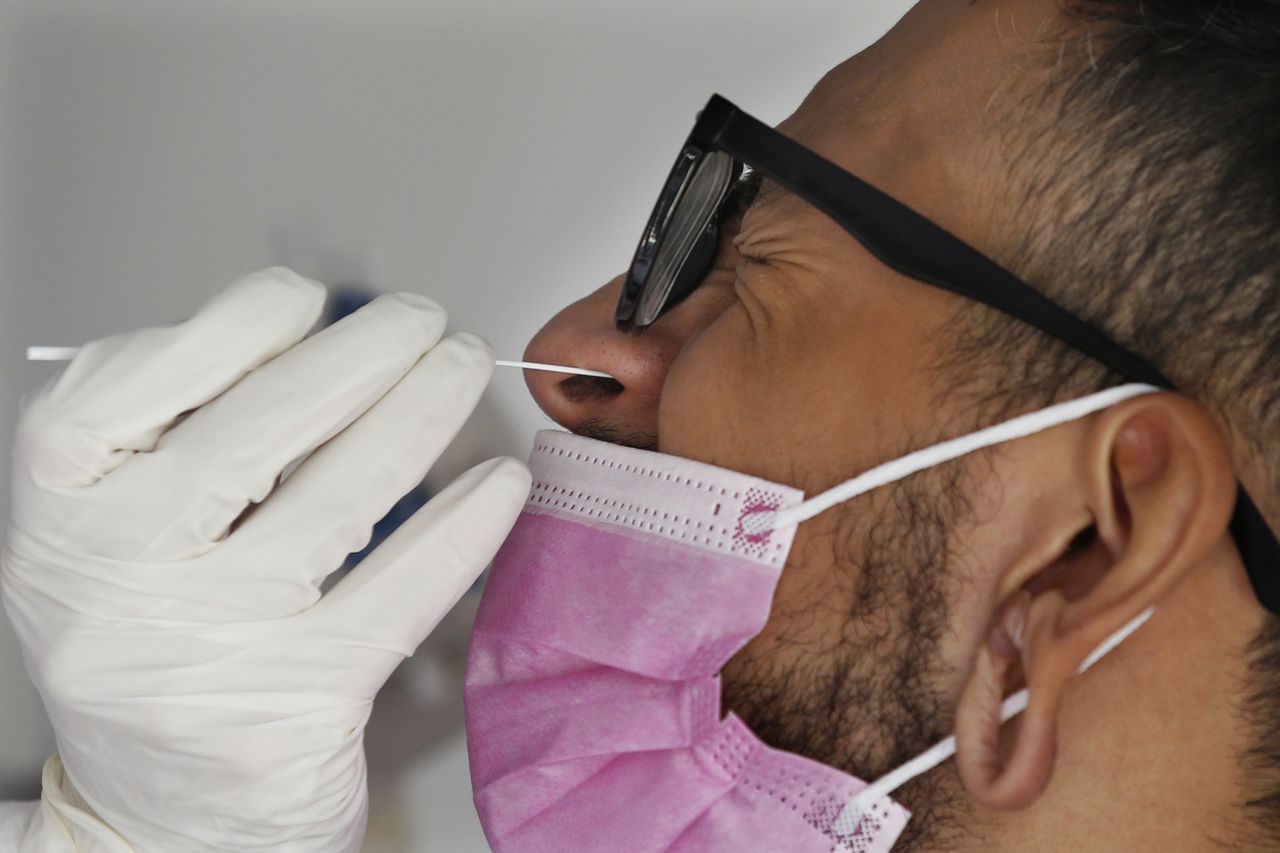Un trabajador de salud recolecta una muestra de hisopado nasal para una prueba de COVID-19. (Foto AP / Marco Ugarte)