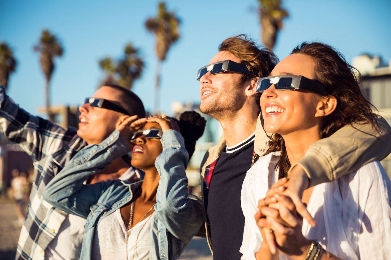 Personas con gafas especiales para ver un eclipse solar.