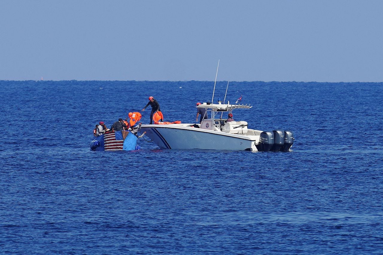 Guardacostas cubanos entregan chalecos salvavidas a hombres que intentaron emigrar ilegalmente a Estados Unidos antes de remolcar su bote cerca del Malecón frente al mar en La Habana, Cuba. REUTERS/Alexandre Meneghini