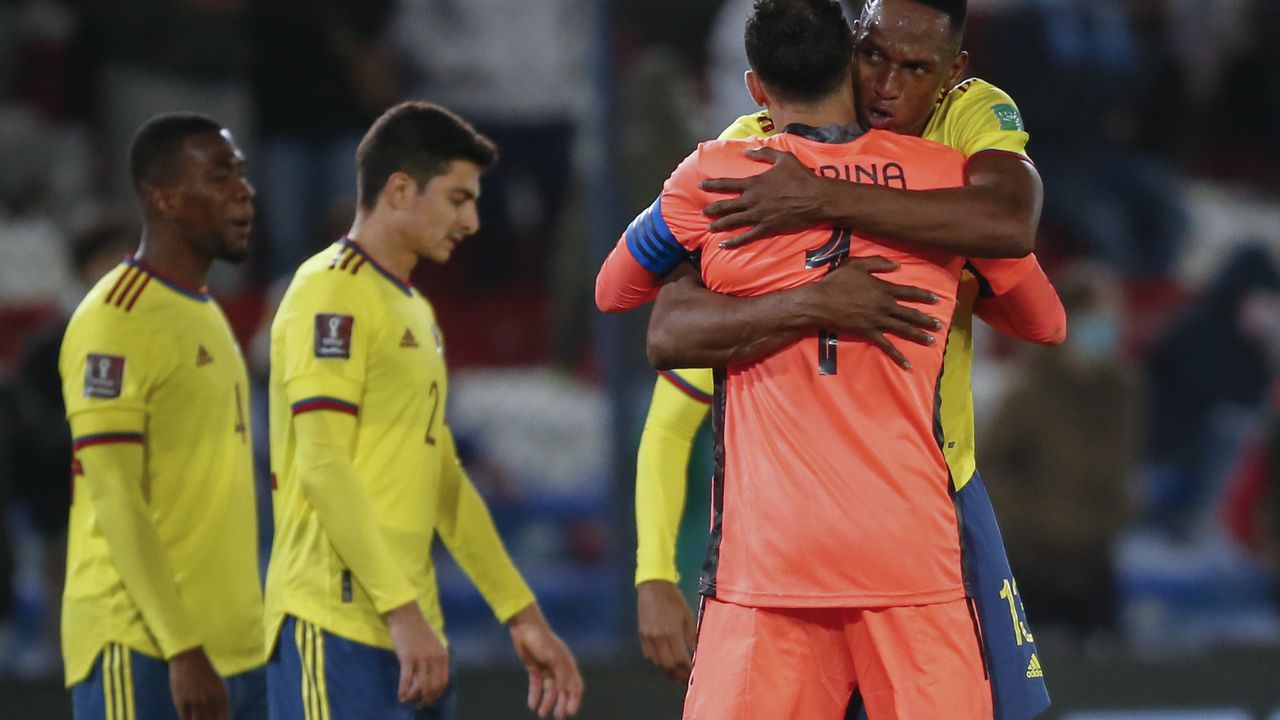 Colombia's Yerry Mina, right, embraces goalkeeper David Ospina at the end of a qualifying soccer match for the FIFA World Cup Qatar 2022 against Uruguay in Montevideo, Uruguay, Thursday, Oct. 7, 2021. The game ended in a 0-0 tie. (Andres Cuenca/Pool via AP)