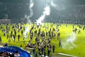 Los fanáticos invaden el campo de fútbol después de un partido entre Arema FC y Persebaya Surabaya en el estadio Kanjuruhan, Malang, Indonesia, el 2 de octubre de 2022