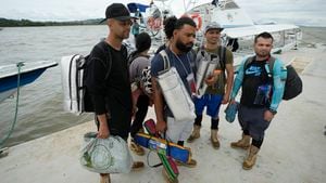 Venezuelan migrant Cristian Casamayor, second from left, arrives to Necocli, Colombia with fellow Venezuelan migrants after they decided against crossing the Darien Gap and returned from Acandi, Thursday, Oct. 13, 2022. Some Venezuelans are reconsidering their journey to the U.S. after the U.S. announced on Oct. 12 that Venezuelans who walk or swim across the border will be immediately returned to Mexico without rights to seek asylum. (AP Photo/Fernando Vergara)