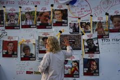 Una mujer mira fotografías de rehenes, en su mayoría civiles israelíes, que fueron secuestrados durante el ataque de Hamás contra Israel el 7 de octubre, en Tel Aviv, Israel, el viernes 24 de noviembre de 2023.