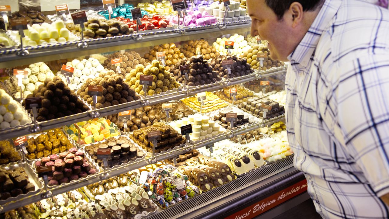 Chocolates, dulces, hombre mirando que comprar de dulces.