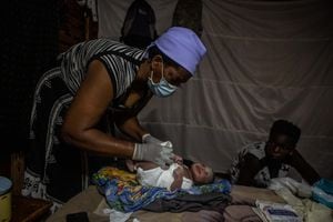 HARARE, ZIMBABWE - 15 DE ENERO: La partera Ivy Gatsi le pone un pañal de tela a una niña recién nacida que nació a primera hora de la mañana en la sala de partos ubicada en su casa el 15 de enero de 2021 en Harare, Zimbabue. El sistema de salud de Zimbabue está abrumado por la pandemia de coronavirus después de que una grave crisis económica sumiera al país en la hiperinflación y la pobreza. (Foto de Tafadzwa Ufumeli/Getty Images)