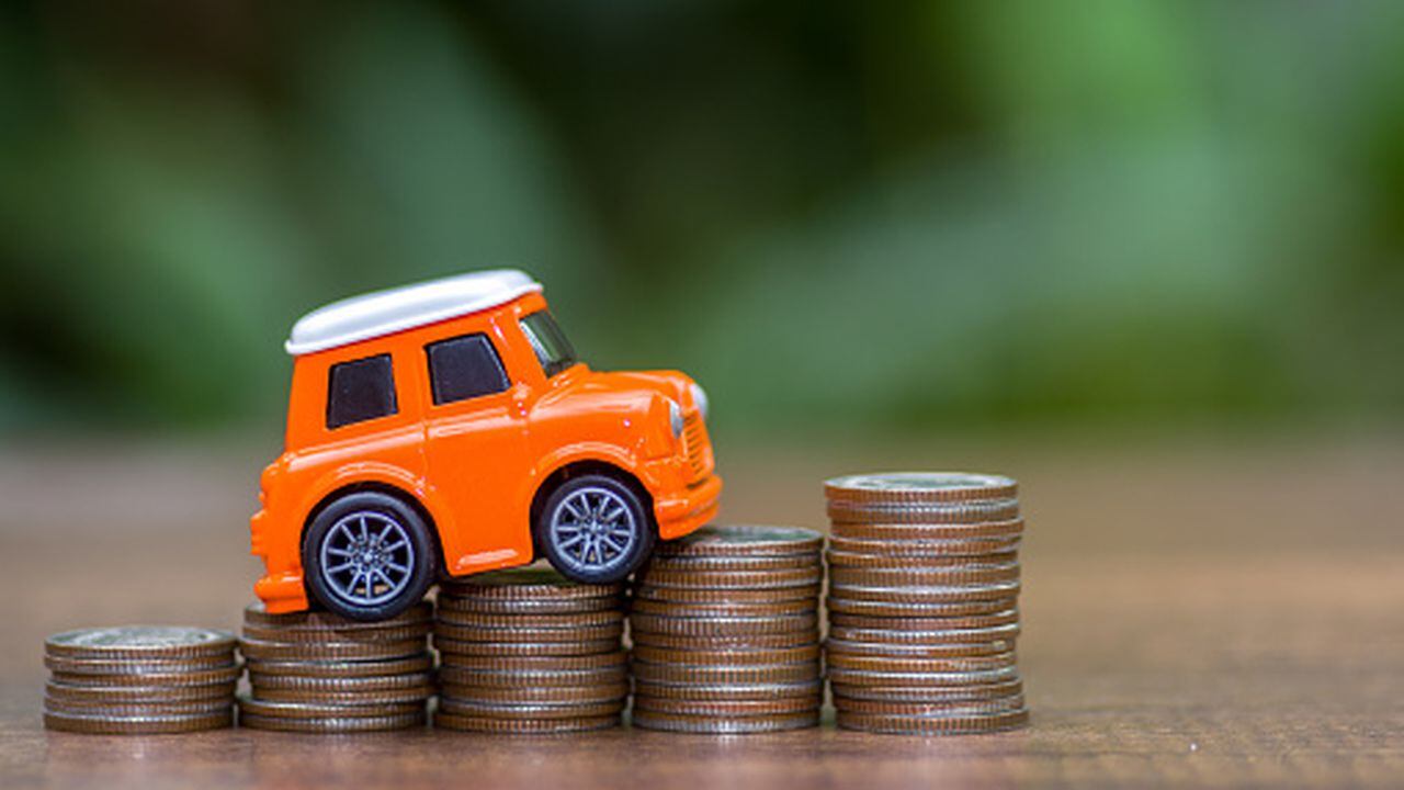 Carro y monedas sobre el precio que vale un seguro