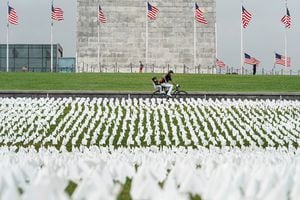Un ciclista pasa junto a una exhibición de banderas blancas que representan a los estadounidenses que han muerto por la enfermedad del coronavirus (COVID-19), ubicada en 20 acres del National Mall, en Washington, EE. UU., El 17 de septiembre de 2021. Foto REUTERS / Joshua Roberts 