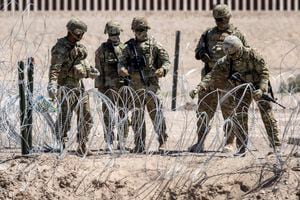 Soldados de la Guardia Nacional de Texas cierran una sección de alambre de púas que rodea un campamento de migrantes improvisado el 11 de mayo de 2023 en El Paso, Texas.