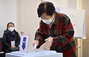 Una mujer emite su voto en las elecciones presidenciales en un colegio electoral en Seúl el 9 de marzo de 2022. (Photo by Jung Yeon-je / AFP)