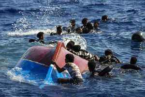 Migrantes nadan junto a su bote de madera volcado durante una operación de rescate de la ONG española Open Arms al sur de la isla italiana de Lampedusa en el mar Mediterráneo, el jueves 11 de agosto de 2022. Foto AP/Francisco Seco