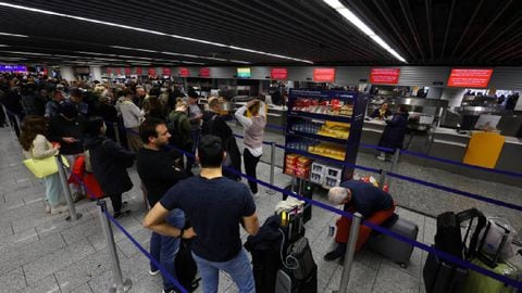Los pasajeros esperan en un mostrador de facturación de Lufthansa después de que una falla que obstaculizó los vuelos.