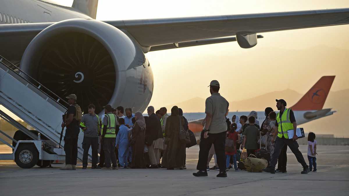 Los pasajeros se preparan para abordar un avión de Qatar Airways en el aeropuerto de Kabul el 9 de septiembre de 2021. - Unos 200 pasajeros, incluidos ciudadanos estadounidenses, salieron del aeropuerto de Kabul el 9 de septiembre de 2021, en el primer vuelo con extranjeros fuera de la capital afgana desde un La evacuación liderada por Estados Unidos terminó el 30 de agosto (Foto de WAKIL KOHSAR / AFP)
