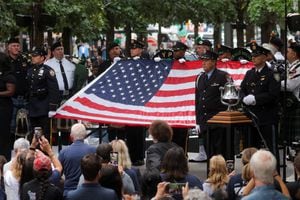 Una bandera estadounidense se sostiene durante la ceremonia de toque de campana, el día del 22º aniversario de los ataques del 11 de septiembre de 2001 contra el World Trade Center en el Museo y Memorial Nacional del 11 de Septiembre