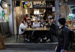 People eat at a restaurant in Jerusalem's main market after authorities reopened restaurants, bars and cafes to "green pass" holders (proof of having received a covid-19 vaccine), on March 11, 2021. (Photo by Emmanuel DUNAND / AFP)