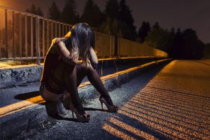 Desperate young woman sitting on the bridge.