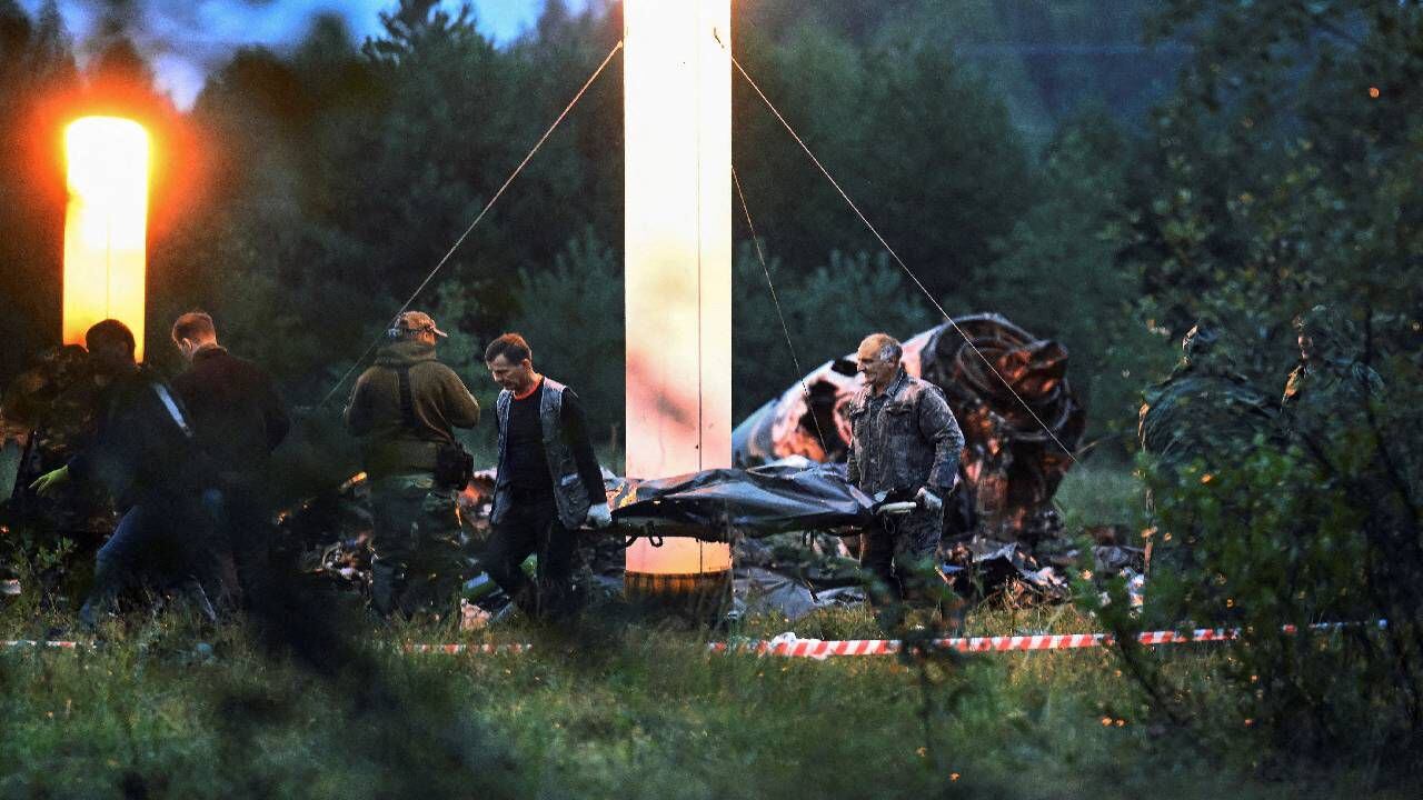 Los especialistas en emergencias llevan una bolsa para cadáveres cerca de los restos del avión privado vinculado al jefe mercenario de Wagner.