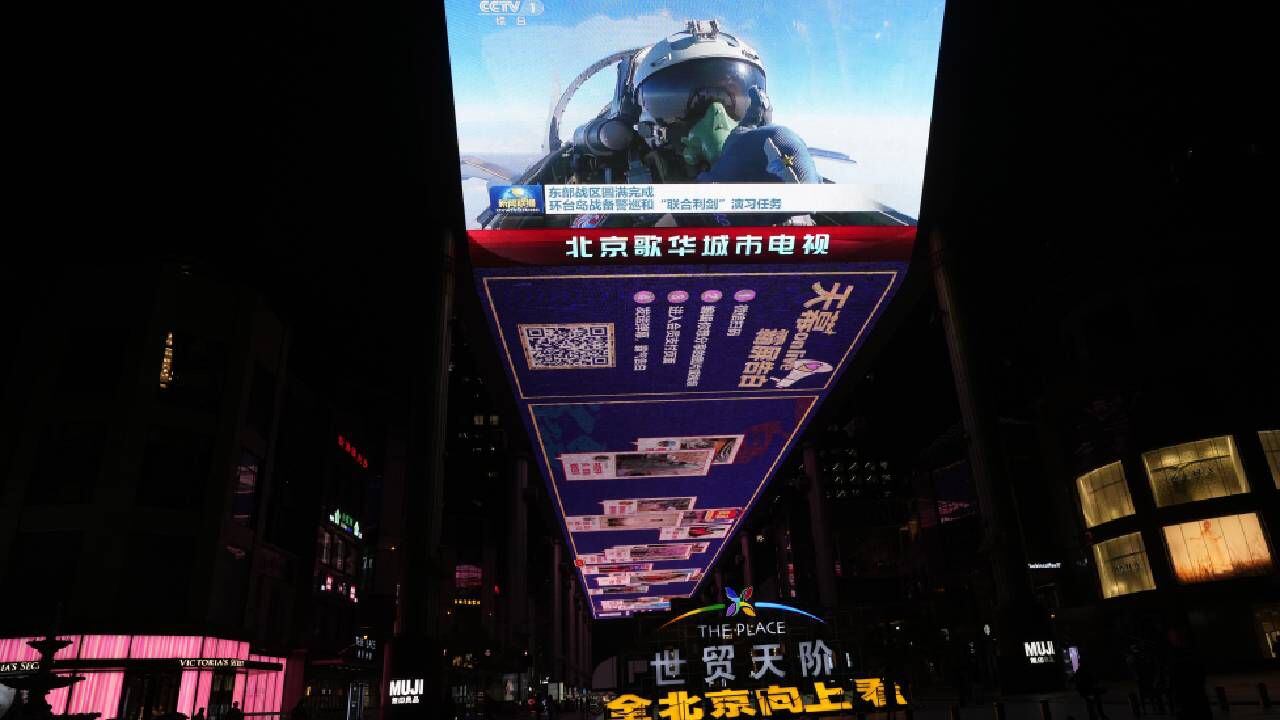 Una pantalla al aire libre muestra a un piloto de avión de combate chino levantando el pulgar en el ejercicio Joint Sword recientemente concluido alrededor de Taiwán durante la transmisión de noticias de la noche.