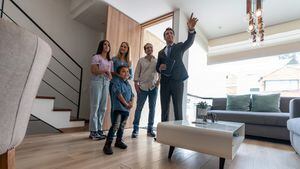 Agente inmobiliario mostrando una casa a una familia latinoamericana interesada en comprar una propiedad - conceptos de propiedad de la vivienda