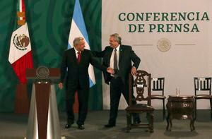 Argentina's President Alberto Fernández, right, arrives with Mexican President Andrés Manuel López Obrador for the Mexican president's daily, morning press conference at the National Palace in Mexico City, Tuesday, Feb. 23, 2021. Fernández is on a four-day official visit to Mexico. (AP Photo/Marco Ugarte)