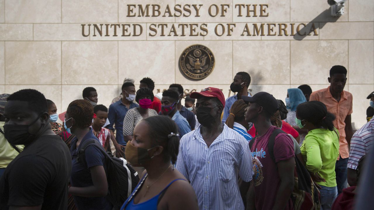 Los haitianos se reúnen frente a la embajada de Estados Unidos en Puerto Príncipe, Haití, en medio de rumores en la radio y las redes sociales de que Estados Unidos entregará visas de exilio y humanitarias, dos días después de que el presidente haitiano Jovenel Moise fuera asesinado en su casa. (Foto AP / Joseph Odelyn)
