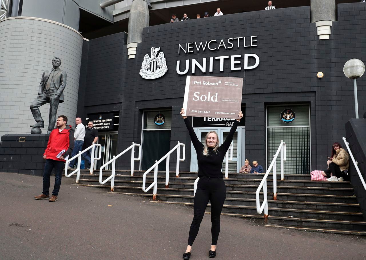 A general view of a Estate Agent holding up a sold sign in front of Newcastle United's stadium ahead of the news of the latest developments in the sale of the club to the Saudi sovereign wealth fund for 300 million-pound ($408 million) takeover in Newcastle Upon Tyne, England Thursday Oct. 7, 2021. (AP Photo/Scott Heppell)