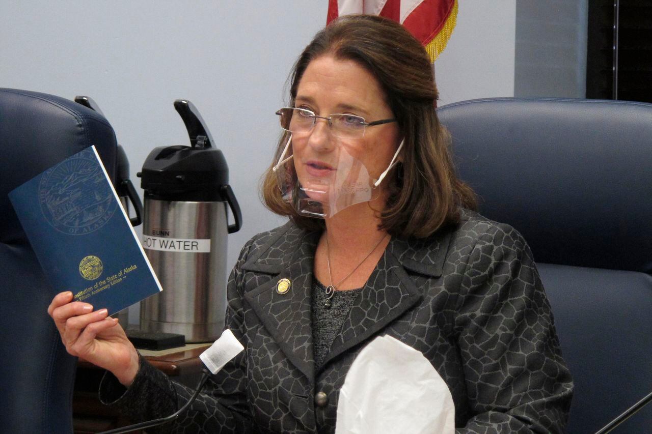 FILE - In this Jan. 27, 2021 file photo, Alaska state Sen. Lora Reinbold, an Eagle River Republican, holds a copy of the Alaska Constitution during a committee hearing in Juneau, Alaska. Alaska Airlines has banned the Alaska state senator for refusing to follow mask requirements. Last week Reinbold was recorded in Juneau International Airport arguing with Alaska Airlines staff about mask policies. A video posted to social media appears to show airline staff telling Reinbold her mask must cover her nose and mouth. Reinbold has been a vocal opponent to COVID-19 mitigation measures and has repeatedly objected to Alaska Airlines' mask policy, which was enacted before the federal government's mandate this year. (AP Photo/Becky Bohrer, File)