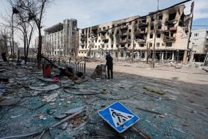 Una residente con sus pertenencias en una calle cerca de un edificio quemado durante el conflicto Ucrania-Rusia, en la ciudad portuaria sureña de Mariupol, Ucrania, 10 de abril de 2022. Foto REUTERS/Alexander Ermochenko.