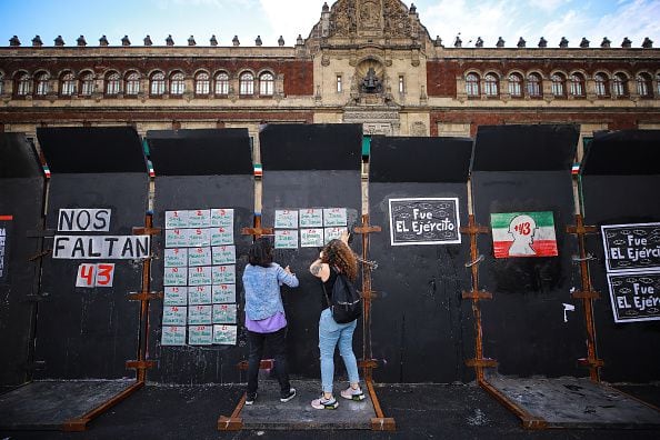 Los manifestantes pintan una pared frente al Palacio Nacional durante una manifestación para conmemorar el 8º aniversario de la desaparición de los estudiantes de Ayotzinapa el 26 de septiembre de 2022 en la Ciudad de México, México. El 26 de septiembre de 2014, 43 estudiantes de la Escuela Rural Isidro Burgos de Ayotzinapa desaparecieron en la ciudad de Iguala tras enfrentamientos con fuerzas policiales. Los estudiantes fueron acusados ​​de intentar el secuestro de autobuses para ser utilizados en protestas. (Foto de Manuel Velásquez/Getty Images)