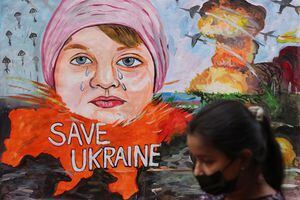 Una niña pasa frente a una pintura que representa la crisis entre Rusia y Ucrania, frente a una escuela de arte en Mumbai, India, el 24 de febrero de 2022. Foto REUTERS/Francis Mascarenhas
