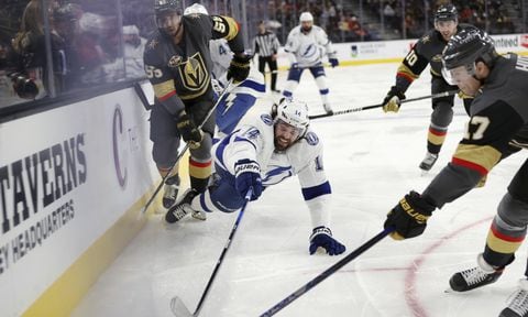 Tampa Bay Lightning left wing Pat Maroon (14) dives for the puck controlled by Vegas Golden Knights defenseman Ben Hutton (17) during the third period of an NHL hockey game Tuesday, Dec. 21, 2021, in Las Vegas. (AP/L.E. Baskow)