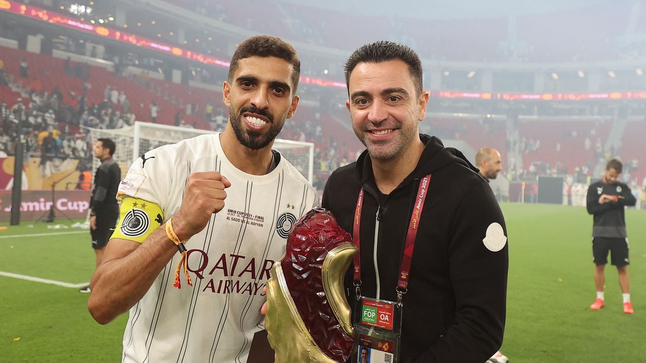 Sadd's coach Xavi (R) and Sadd's midfielder Hassan al-Haydos celebrate with the trophy after winning the Amir Cup final football match between Al-Sadd and Al-Rayyan at the Al-Thumama Stadium in the capital Doha on October 22, 2021.
KARIM JAAFAR / AFP